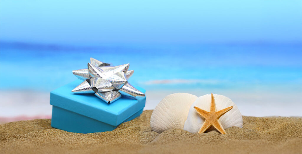 LeBarge-Tropical-Cruises-Gift-Certifcates Wrapped gift in the sand with shells and sand dollar
